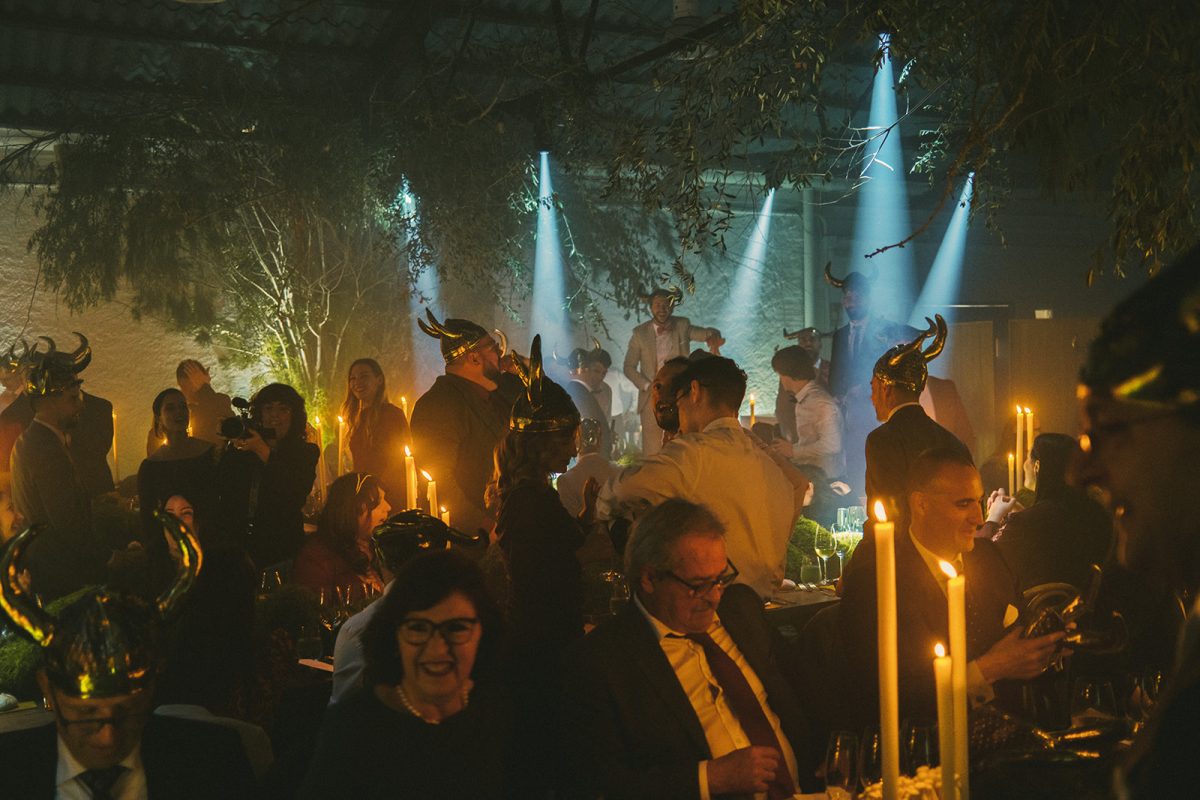 Mesa larga decorada con velas altas, musgo y cristalería en un ambiente estilo bosque encantado para cena de boda elegante.