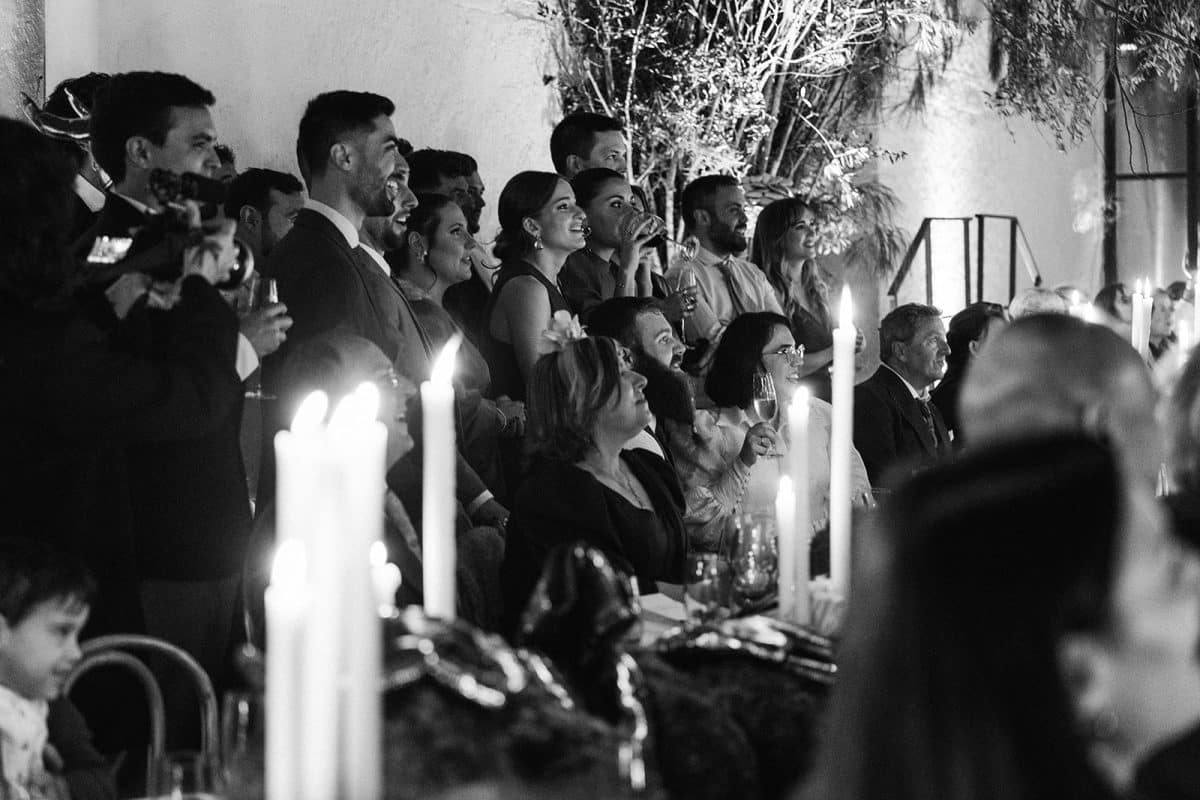 Mesa larga decorada con velas altas, musgo y cristalería en un ambiente estilo bosque encantado para cena de boda elegante.