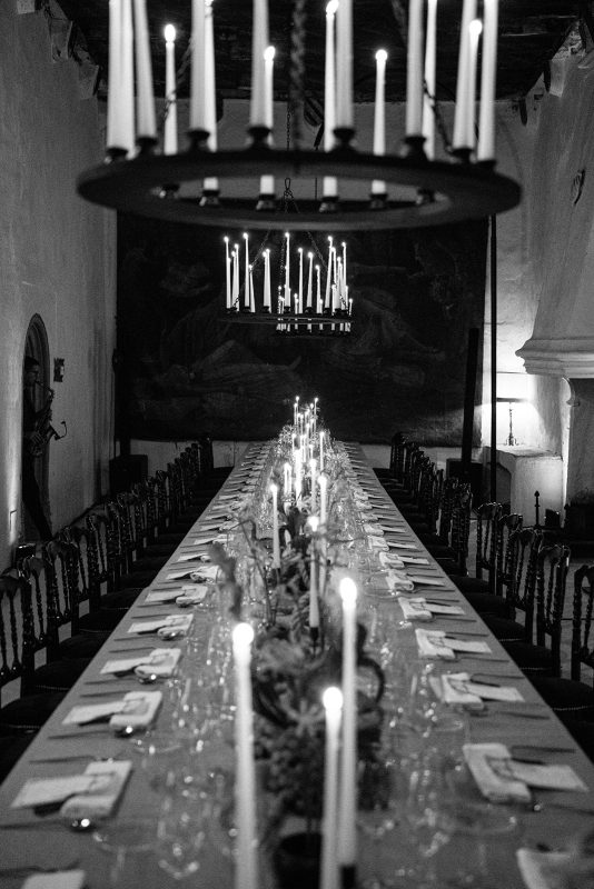 Mesa de boda con mantel morado, velas y lamparas de candelabro