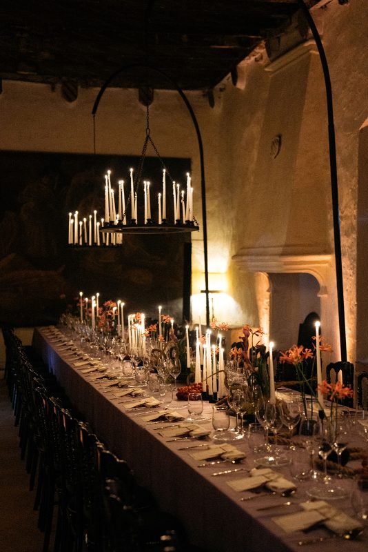 Mesa de boda con mantel morado, velas y lamparas de candelabro
