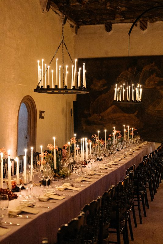 Mesa de boda con mantel morado, velas y lamparas de candelabro
