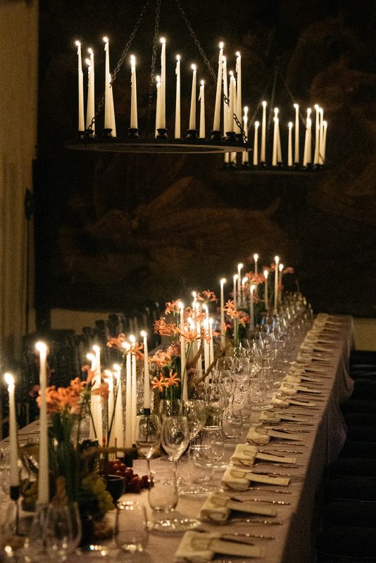 Mesa de boda con mantel morado, velas y lamparas de candelabro