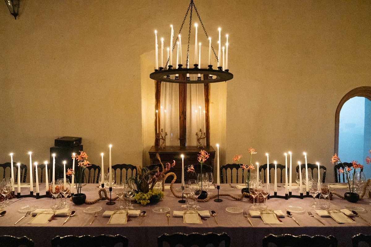 Mesa de boda con mantel morado, velas y lamparas de candelabro