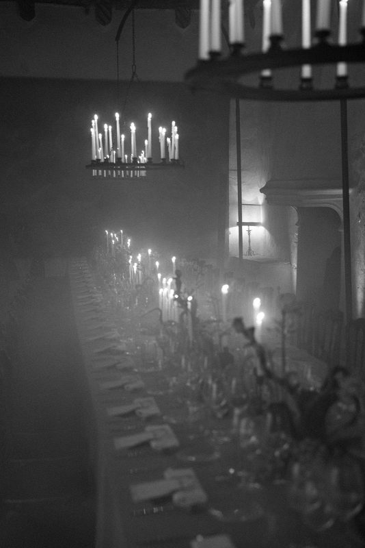Ambiente de cena con velas y humo, candelabros y lamparas repletas de velas