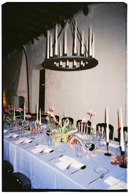 Mesa de boda con mantel morado, velas y lamparas de candelabro