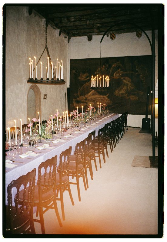 Mesa de boda con mantel morado, velas y lamparas de candelabro
